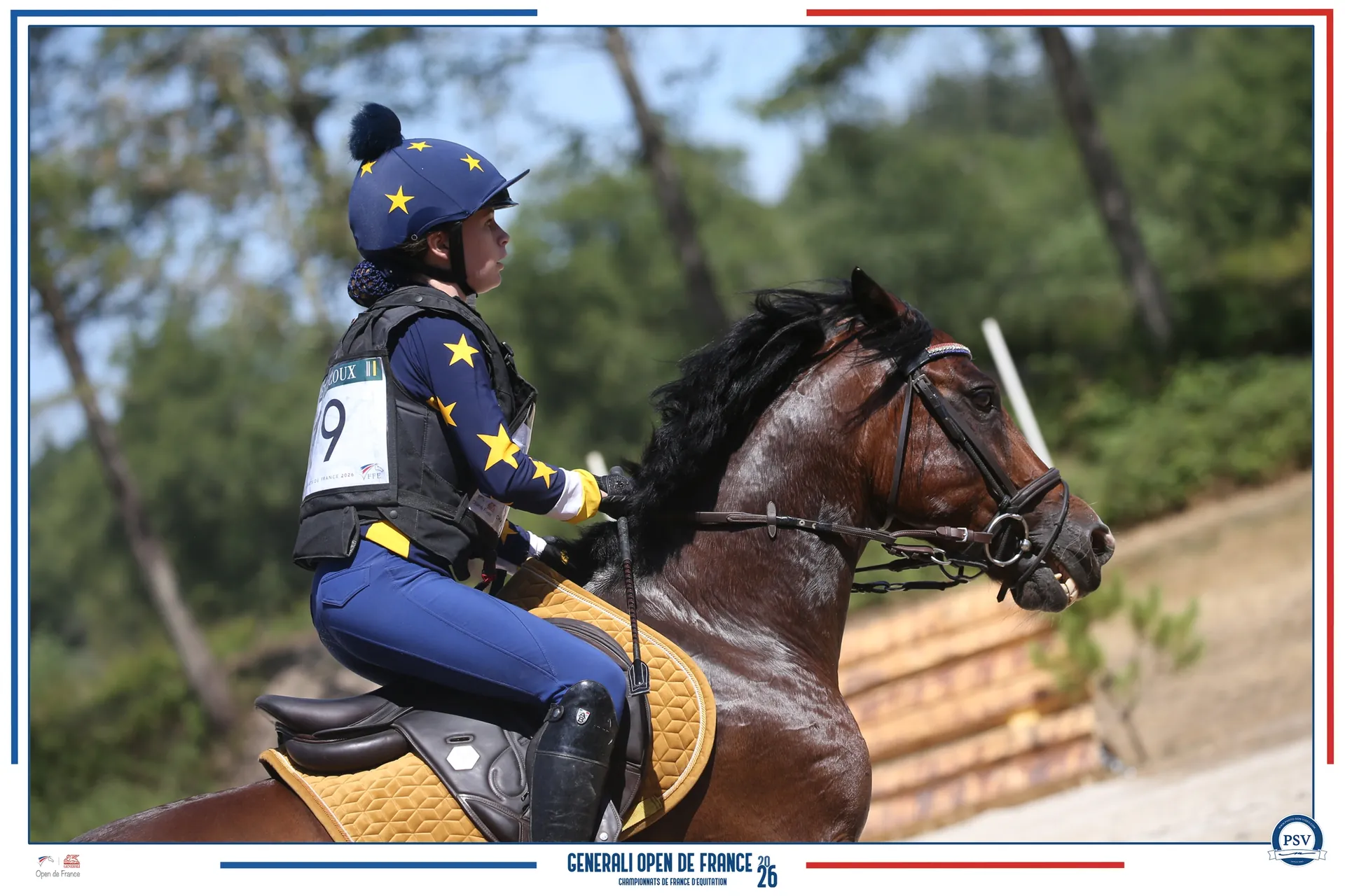 Une cavalière en tenue bleue et jaune avec son poney sur un parcours de cross