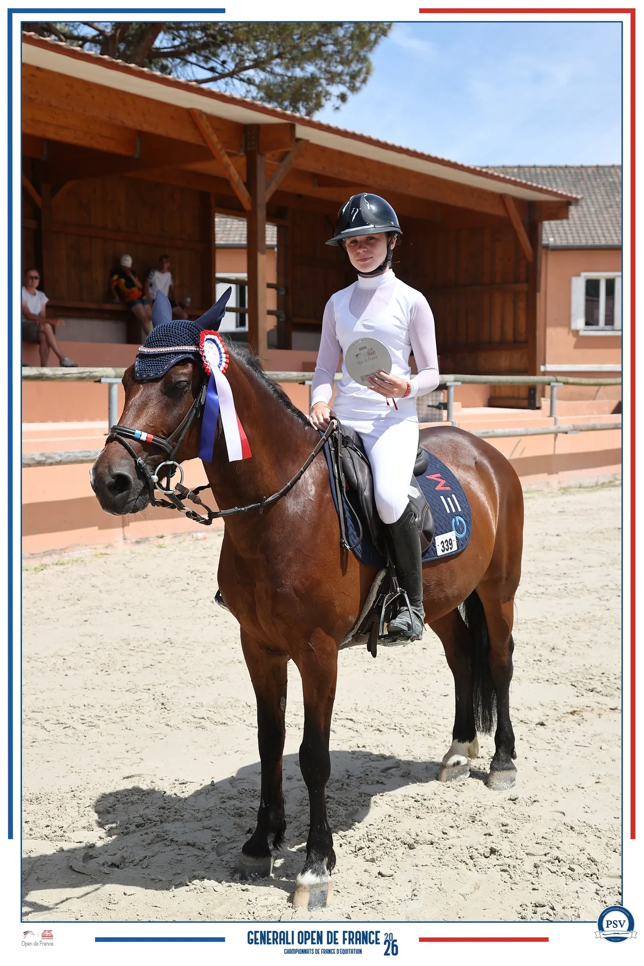 Une cavalière à cheval tenant une récompense après une épreuve