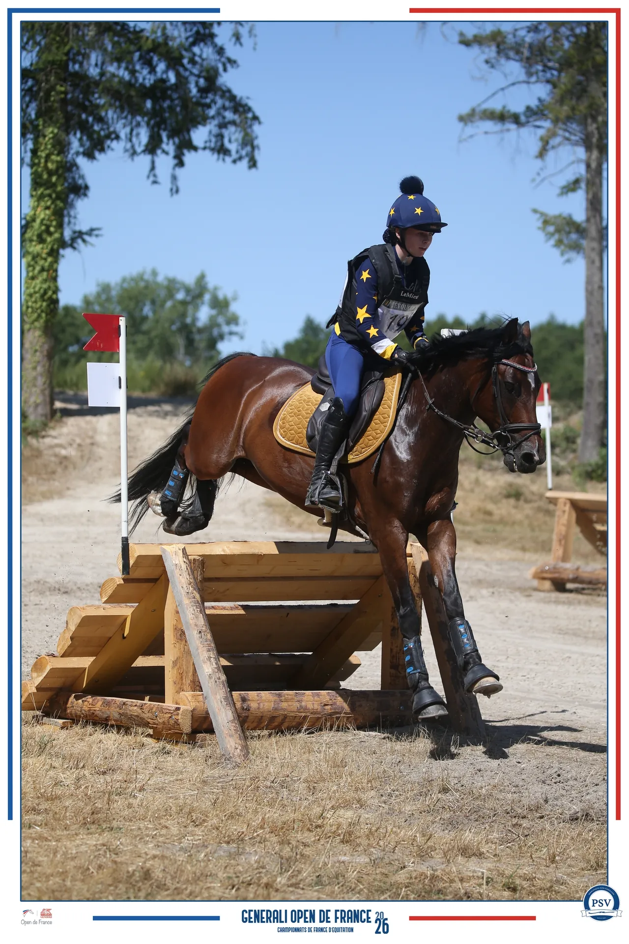 Une cavalière et son poney franchissant un obstacle en bois sur le cross